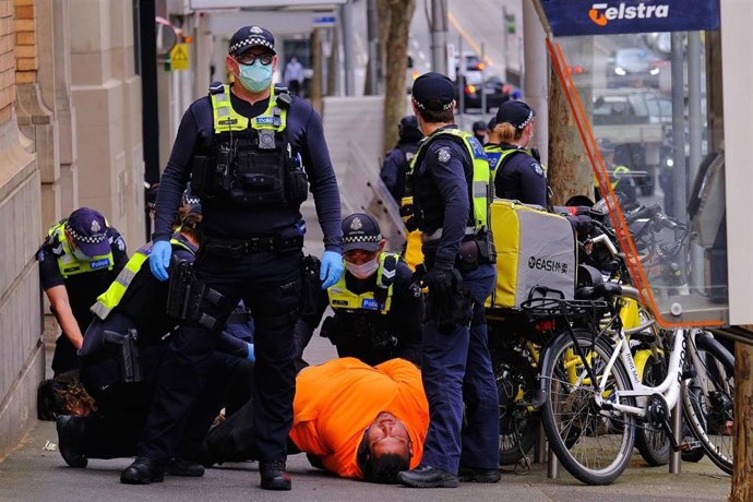 La Policía de Australia detiene a un manifestantes durante las protestas de Melbourne.