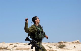 Archivo - Un Policía israelí lanzando un objeto contra manifestantes palestinos