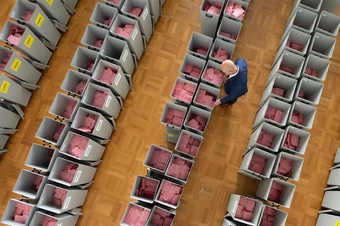 FILED - 22 September 2021, Saxony, Dresden: Markus Blocher, district election officer, inspects numerous ballot boxes filled with ballot paper envelopes for the postal vote in an election office. Around 3.3 million eligible voters in Saxony can cast the
