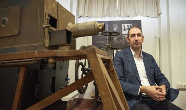 Ángel Justo, responsable de la Fototeca, posa en las instalaciones de este servicio junto a algunos de los equipos históricos almacenados en el mismo