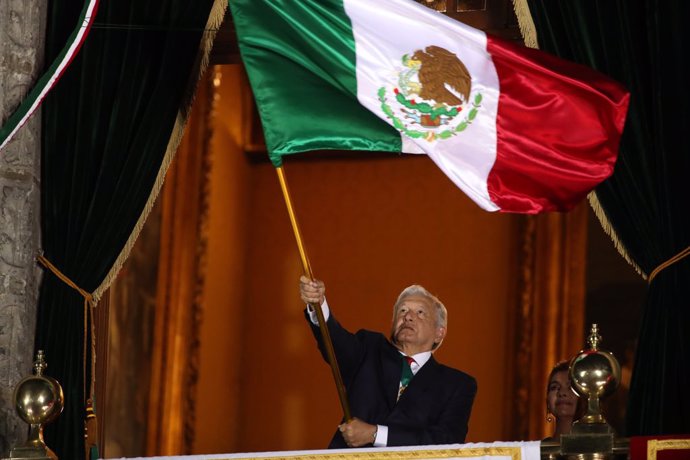 15 September 2021, Mexico, Mexico City: Mexican President Andres Manuel Lopez Obrador waves the Mexican national flag during the ceremony of the Grito de Independencia (the Cry of Independence) from the National Palace on the eve of the Independence Day