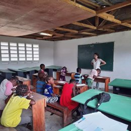 Una voluntaria de Educaguinea imparte clases a niños en la escuela remodelada de Mebere durante el verano de 2021