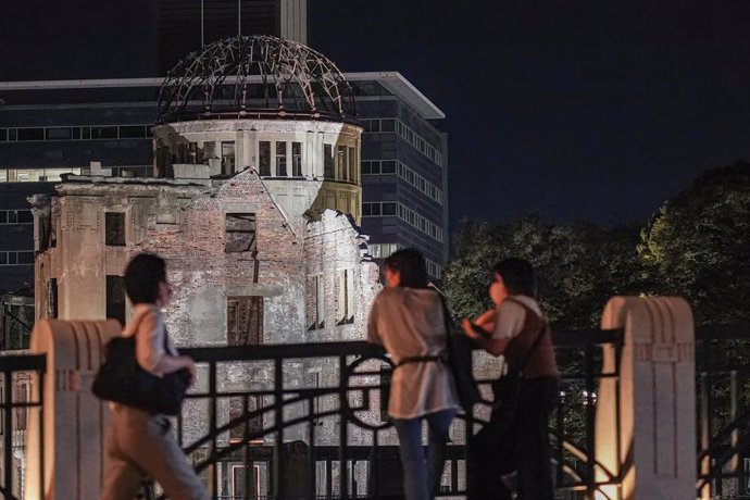 Archivo - 05 August 2021, Japan, Hiroshima: People look at the Atomic Bomb Dome that lights up at night in the Peace Memorial Park ahead of the 76th anniversary of the atomic bombing in Hiroshima and Nagasaki by the United States during World War II. Ph