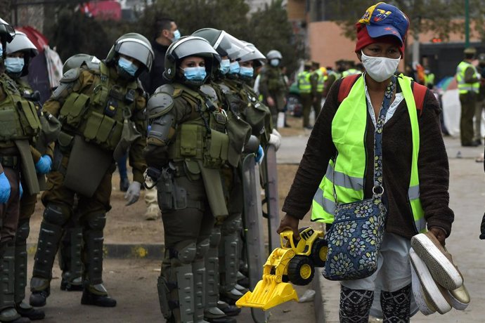 Forces de seguretat xilenes vigilen el desallotjament d'un campament de migrants veneolans en Iquique