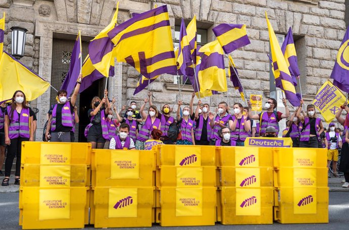 Archivo - 25 June 2021, Berlin: Supporters of the initiative "Expropriate Deutsche Wohnen & Co." wave flags as they bring boxes with collected signatures for a referendum on the expropriation of large real estate companies to the Senate Department for t
