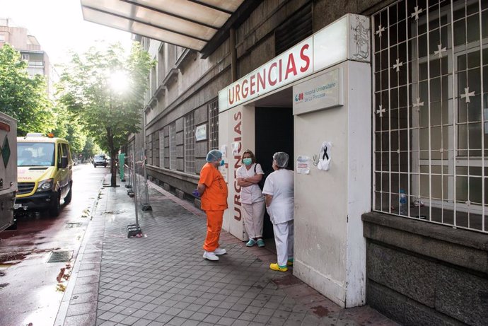 Archivo - Varios sanitarios en la puerta de Urgencias minutos antes de que de comienzo el homenaje a los sanitarios en el Hospital de la Princesa