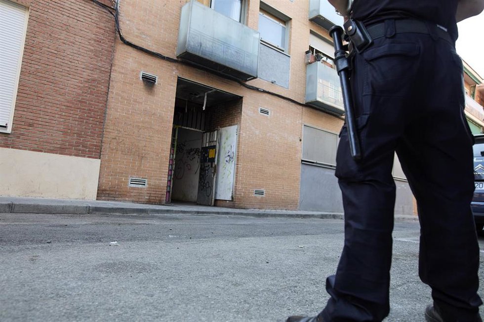 Archivo - Un agente de Policía Nacional frente a un edificio de la calle José Garrido que estaba okupado, a 20 de julio de 2021, en Madrid (España).