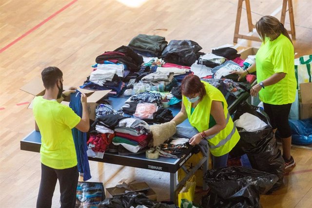 Varias personas colaboran y apilan ropa y objetos en el Polideportivo Severo Rodríguez, donde se almacenan donaciones para los afectados por la erupción del volcán de ‘Cumbre VIeja