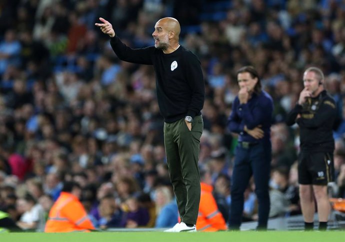 21 September 2021, United Kingdom, London: Manchester City manager Pep Guardiola instructs his players as Wycombe Wanderers' Gareth Ainsworth looks on during the English Carabao Cup third round soccer match between Manchester City and Wycombe Wanderers 