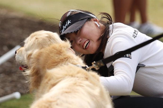 Una mujer coreana junto a un perro