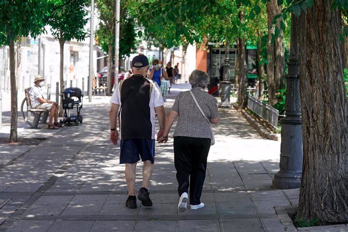 Archivo - Una pareja de ancianos camina por la calle cogida de la mano, a 27 de julio de 2021, en Madrid, (España). La Seguridad Social destinó en el presente mes de julio la cifra récord de 10.202,29 millones de euros al pago de pensiones contributivas