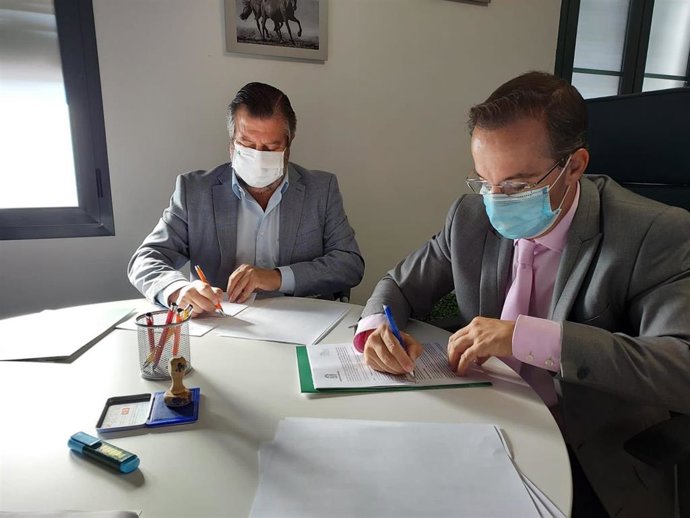 Firma del acuerdo entre el delegado territorial, Alfredo Martín, y el alcalde de Hinojos, Miguel Ángel Curiel.