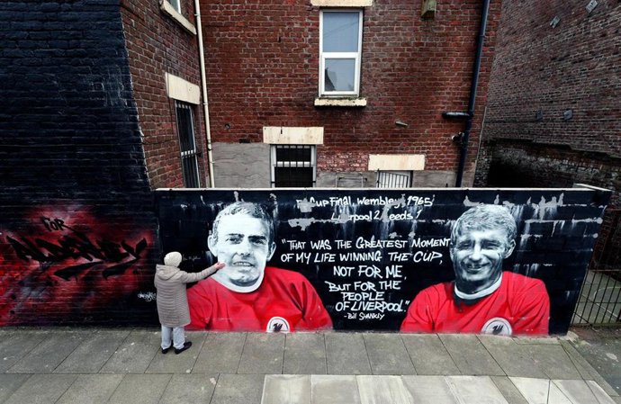 Archivo - Una mujer toca un mural de Ian Saint John, que lo representa junto a su compañero de ataque y héroe de la Copa del Mundo para Inglaterra, Roger Hunt