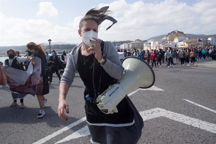 Archivo - Una mujer sostiene un megáfono durante una manifestación en apoyo a las 87 mujeres que en 2019 fueron grabadas sin autorización, a 4 de abriil de 2021, en la playa de Torno, en San Cibrao, Lugo, Galicia (España). 