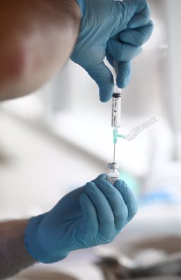 Archivo - Un sanitario prepara una de las dosis de la vacuna Pzifer antes de suministrarsela a un anciano