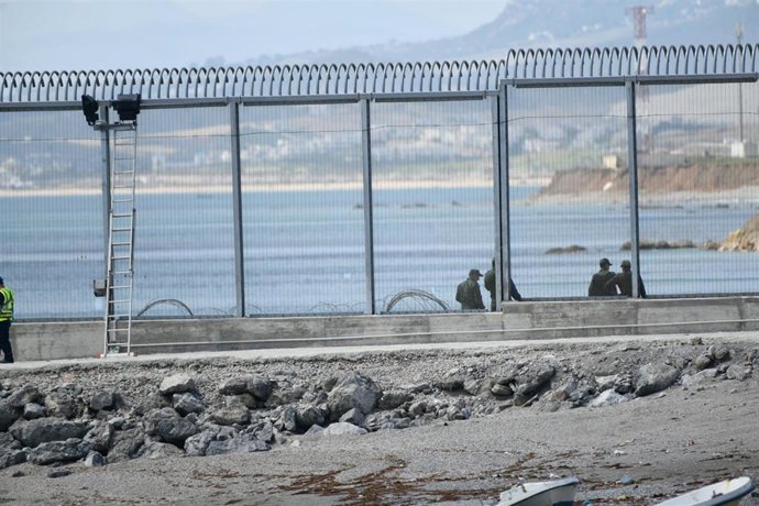 Archivo - Imagen de archivo de agentes de la Gendarmería Real marroquí y Fuerzas auxiliares (Mejania) levantan alambradas de concertinas en la parte inferior del vallado en el espigón del Tarajal, a 1 de junio de 2021, en Marruecos. 