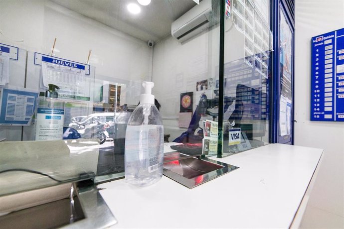 Archivo - Interior de una administración de lotería de la capital con gel desinfectantes para los clientes.
