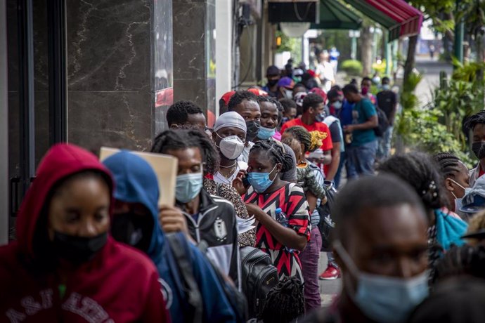 Ciudadanos haitianos hacen cola ante las oficinas de la Comisión Mexicana de Ayuda a Refugiados, en Ciudad de México