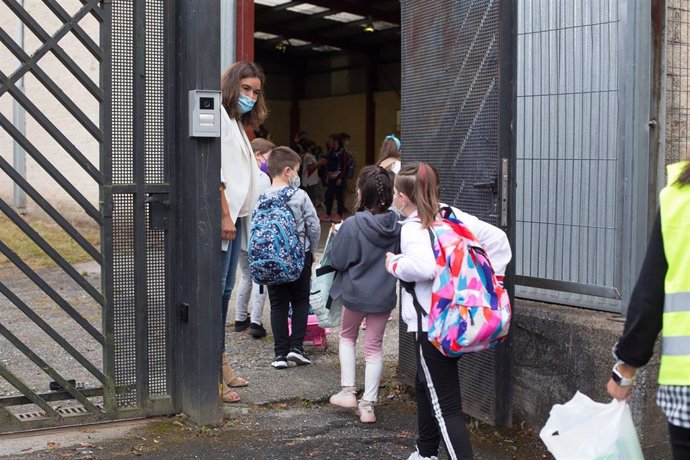 Varios niños y niñas entran en un centro educativo.