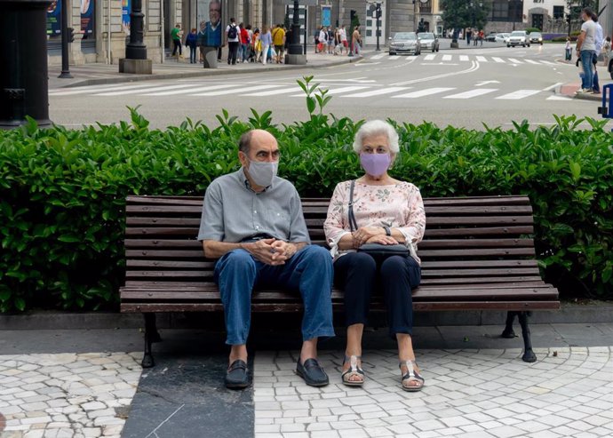Archivo - Pareja de ancianos con mascarillas sentados en un banco de Oviedo durante el verano de la pandamia del covid 19. Oviedo a 25 de agosto del 2020