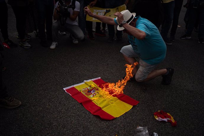 Queman banderas de España durante la protesta contra Felipe VI en Barcelona.