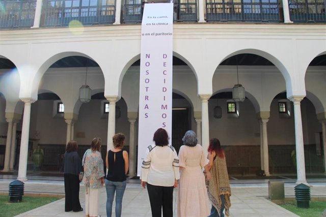 Las diputadas de Adelante Andalucía, ante la pancarta desplegada en el Parlamento de Andalucía.