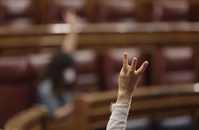Archivo - Un miembro del hemiciclo vota durante una sesión plenaria en el Congreso de los Diputados