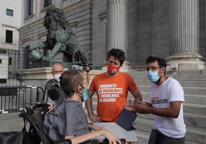 El portavoz de Unidas Podemos en el Congreso, Pablo Echenique (centro) y el portavoz del BNG en el Congreso, Néstor Rego (1i, detrás), en la presentación de la Ley de garantía del derecho a la vivienda digna y adecuada, en la Plaza de las Cortes.