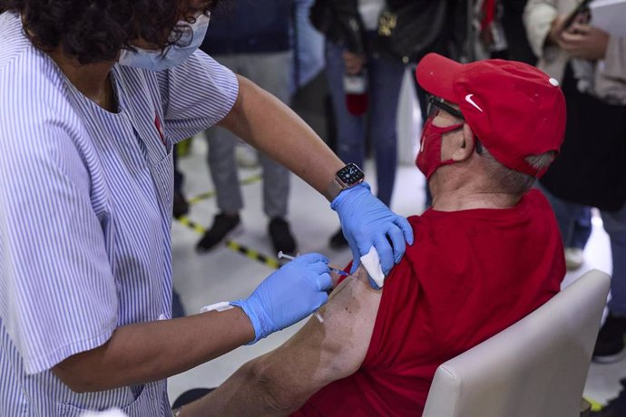 Una sanitaria vacuna a un mayor en una residencia