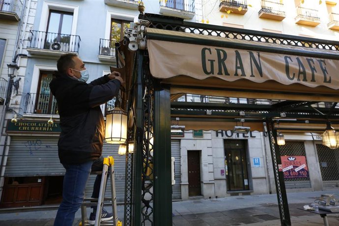 Archivo - Camareros limpiando y poniendo las mesas en las terrazas de los bares a primera hora de la mañana, en noviembre de 2020
