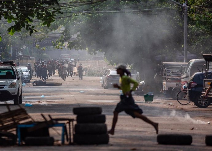 Archivo - Un manifestante corre mientras la policía lanza botes de gas lacrimógeno durante los enfrentamientos en medio de las protestas contra el golpe militar y la detención de líderes civiles.