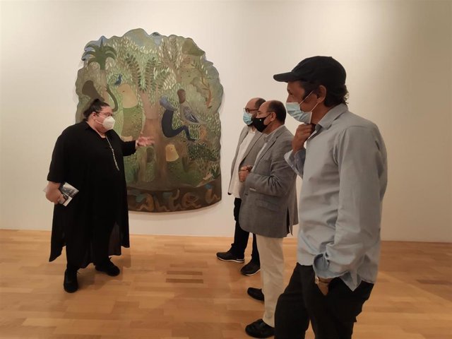 Responsables de la exposición 'Cantos de Griot' delante de una de las obras expuestas en el DA2 de Salamanca.