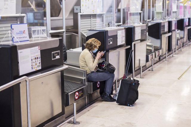 Una mujer espera su vuelo en Barajas.