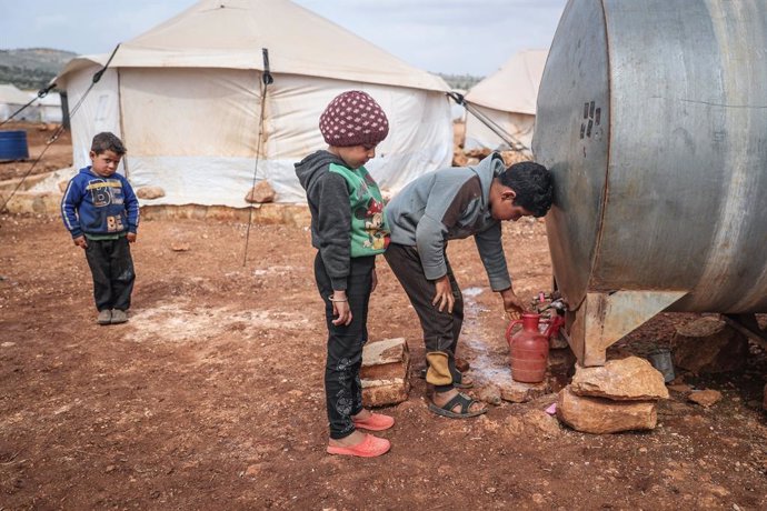 Archivo - 11 March 2021, Syria, Kafr Aruq: Syrian children bottle water from a water container at a refugee camp for internally displaced people in the village of Kafr Aruq. On Wednesday, UN Secretary-General Antonio Guterres has underlined that the Syr