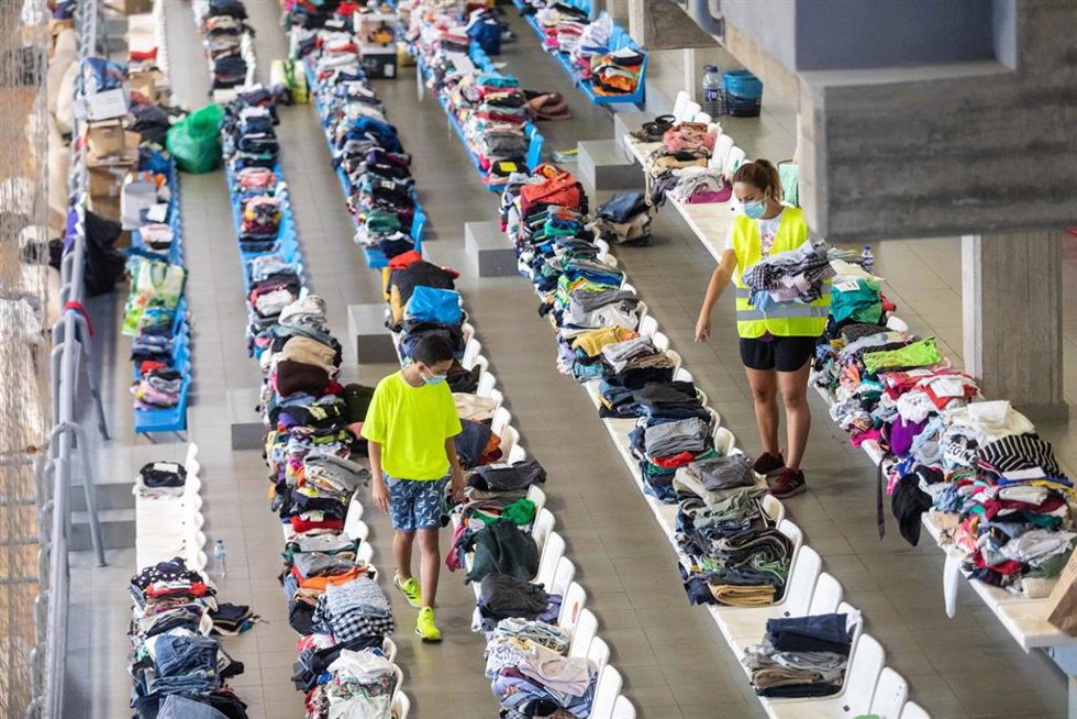 Varias personas colaboran y apilan ropa y objetos en el Polideportivo Severo Rodríguez, donde se almacenan donaciones para los afectados por la erupción del volcán de Cumbre VIeja