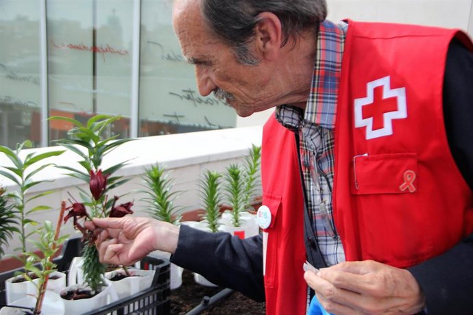 Un hombre mayor con chaleco de Cruz Roja.