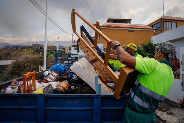 Dos hombres de mantenimiento del Ayuntamiento colaboran en recoger las pertenencias de los vecinos del núcleo urbano de Todoque 