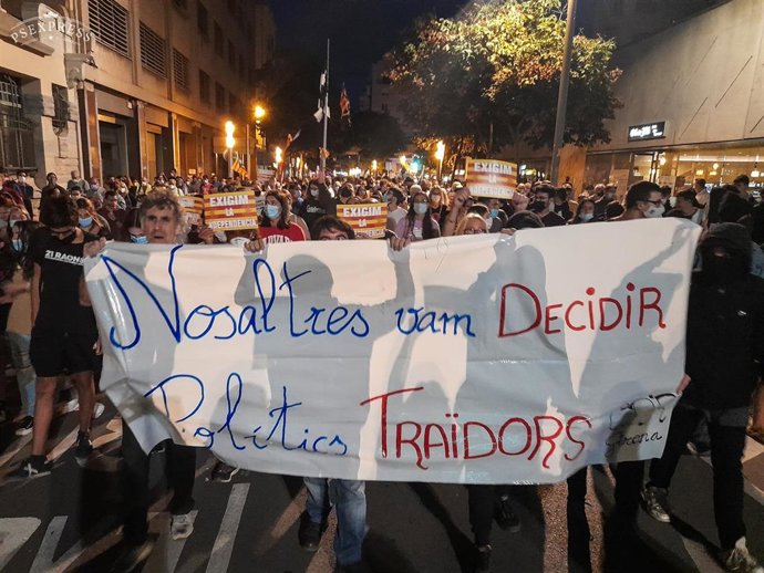 Varias personas con una pancarta en la que se lee: 'Nosaltres vam decidir, politics traidors', durante una manifestación por el referéndum del 1-O en Girona. 