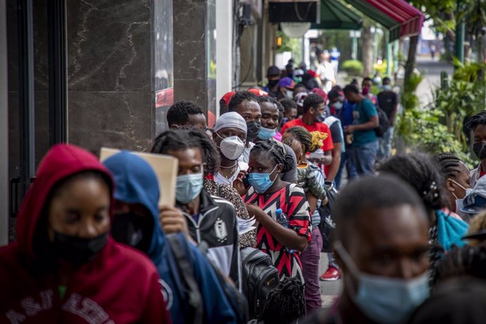 23 September 2021, Mexico, Mexico City: Migrants queue in front of the The Mexican Commission for Refugee Assistance office, where they want to apply for asylum. Migrants from Haiti have arrived in the Mexican capital from the south in the last three da
