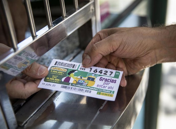 Archivo - Un vendedor de cupones atiende su puesto 