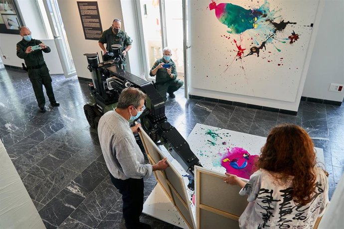 El artista Fernando Sánchez Castillo, junto a tres guardias civiles, durante una actividad artística realizada con robots desactivadores de explosivos, en el Centro Memorial de las Víctimas del Terrorismo.