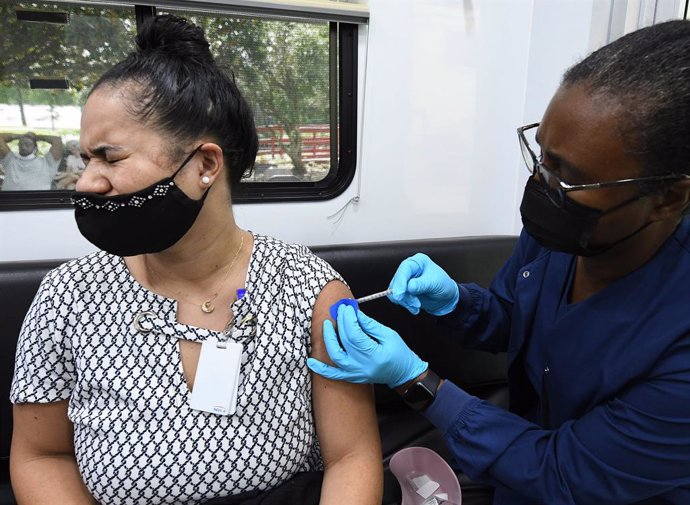Archivo - 21 July 2021, US, Orlando: Annie Velez (L)receives a shot of the Pfizer coronavirus vaccine at a mobile COVID-19 vaccination site. New COVID-19 cases in Florida have doubled in the past week, with most cases identified as the highly contagiou