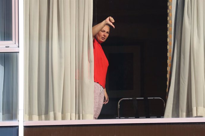 Archivo - 15 February 2021, United Kingdom, Heathrow: A female hotel guest, gives a thumbs down gesture to members of the media from the window of Radisson Blu Edwardian Hotel, near Heathrow Airport, London, one of the new Government managed quarantine 