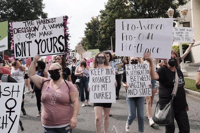02 October 2021, US, Atlanta: Protesters hold placards as they march through downtown Atlanta during an abortion rights protest in Atlanta. Photo: John Arthur Brown/ZUMA Press Wire/dpa