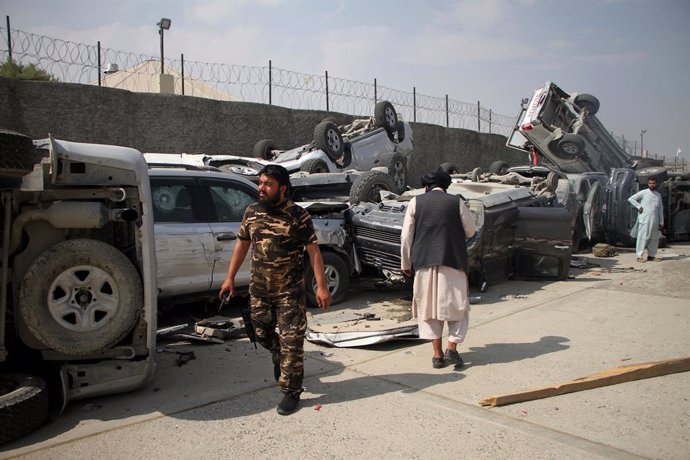 (210921) -- KABUL, Sept. 21, 2021 (Xinhua) -- Taliban members walk past damaged vehicles at the Kabul airport in Kabul, capital of Afghanistan, Sept. 20, 2021. The Kabul airport were damaged with its many facilities destroyed during the withdrawal of th