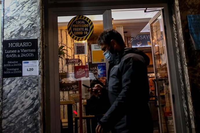 Archivo - Un hombre pasa por delante de un bar 