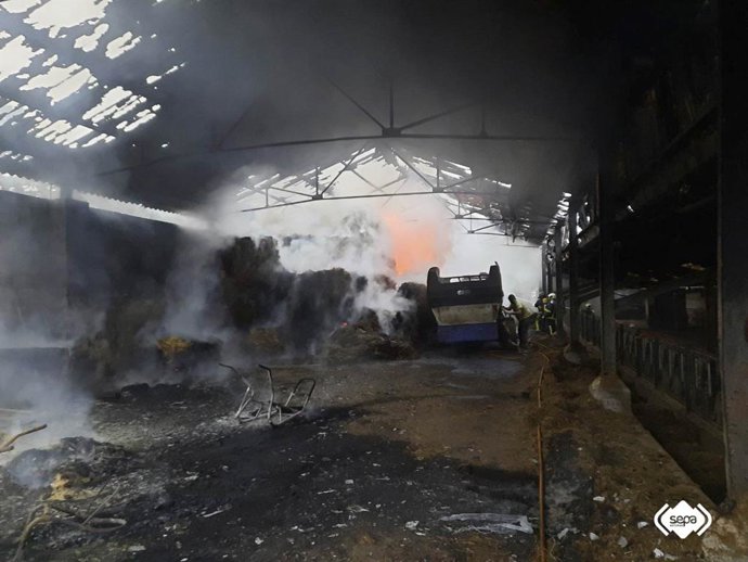 Bomberos controlan un incendio en una nave ganadera ubicada en la localidad de Villayo, en Llanera.