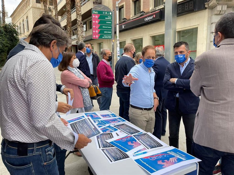 Erik Domínguez y Toni Martín (c), en la mesa de la campaña sobre la subida de luz.