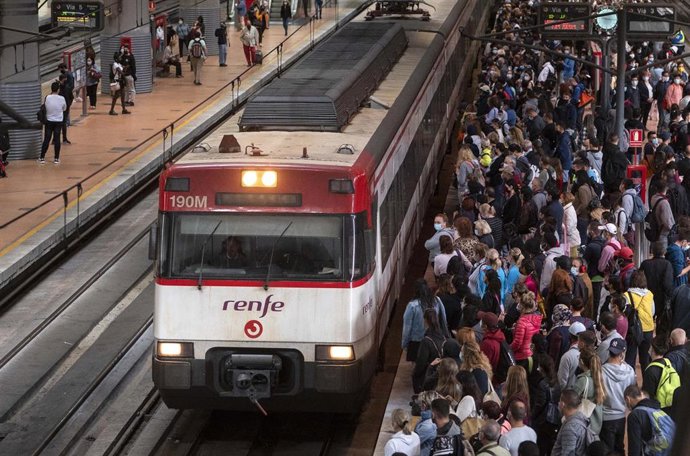 Un gran número de pasajeros espera la llegada de un tren en la estación de Madrid - Puerta de Atocha