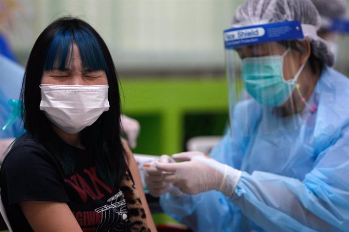 04 October 2021, Thailand, Bangkok: A health worker administers Pfizer vaccine to a high school student at Prachaniwet Secondary School in Bangkok.